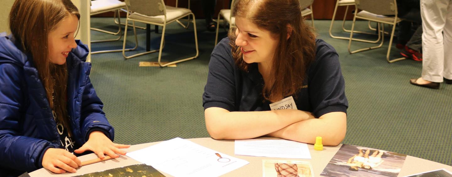 Archivist and student smiling at each other while working with historical documents